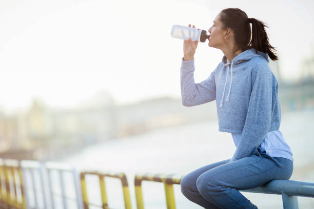 istock Young female resting after running and drinking water 672600012