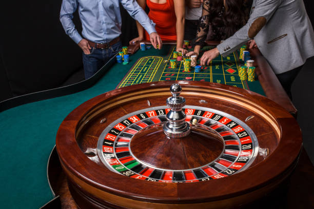 ルーレットのテーブルの後ろに若い人たちのグループ - roulette wheel ストックフォトと画像