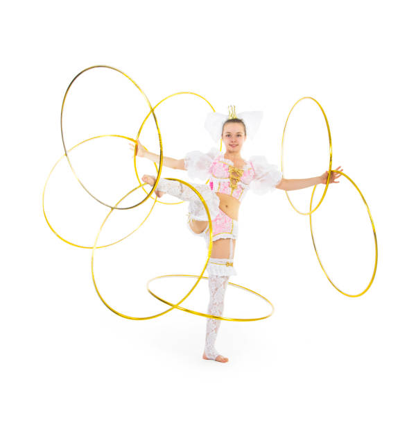 A little girl gymnast in a hare costume spins gymnastic hoops.