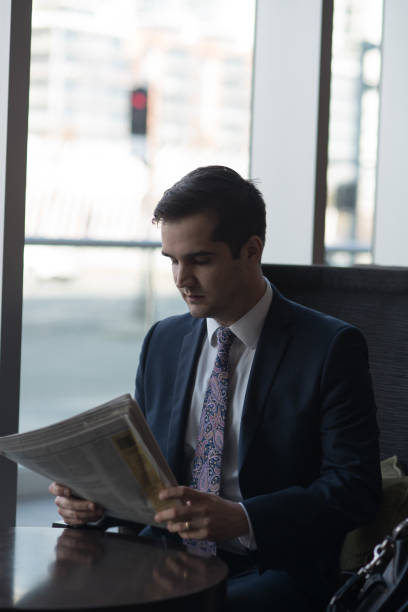 istock Business Traveller Reading Paper in Lounge 672647092