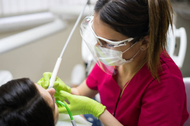 dentista pulizia denti di donna - igienista dentale foto e immagini stock