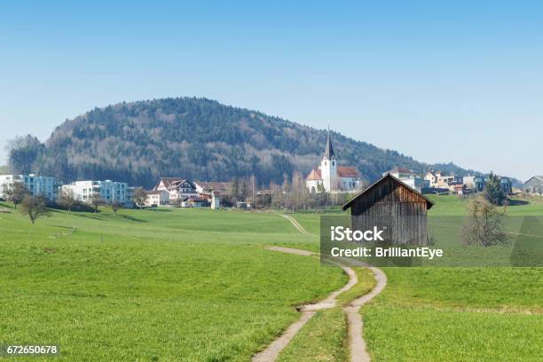 Country Landscape Dirt Road In Front Of Swiss Village Stock Photo - Download Image Now