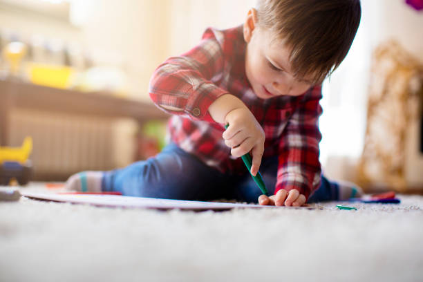 istock Beautiful little boy coloring at the floor 672657500