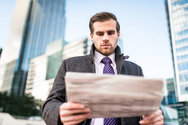 istock Businessman portrait reading the newspaper 672661644