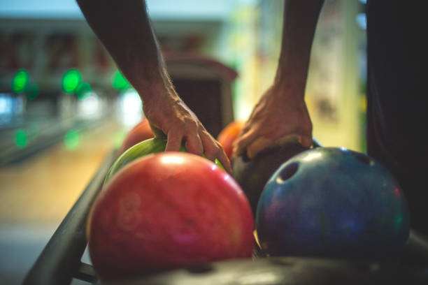 Two men taking balls to bowl Colorful image of a few bowling balls in a row and two men are taking their balls to throw sports league stock pictures, royalty-free photos & images