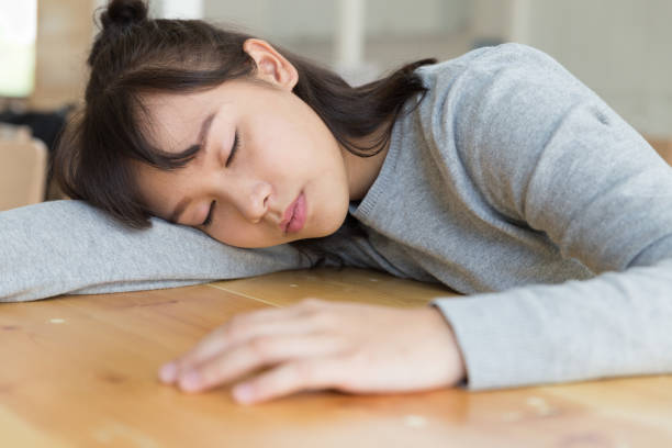 istock tired student girl sleeping on the table. studying hard, education, session, exams and school concept. 672689462