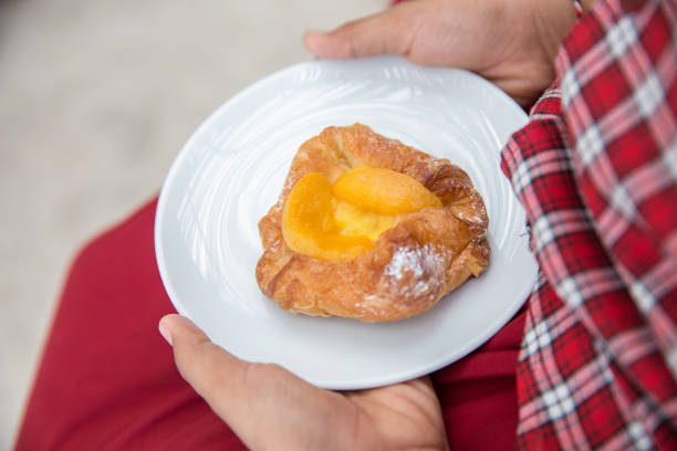 A plate of  of mini danish pastries with lemon cheesecake filling on top, white background with copy space.