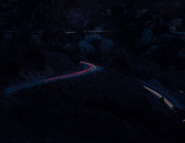 istock Cars Create Light Trails on a Coastal Mountain Road 672717394