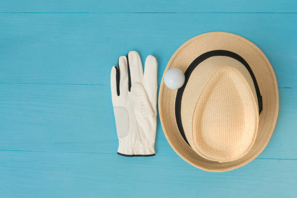 istock Golf concept : panama hat, glove, golf balls on wooden table. Flat lay with copy space. 672741586