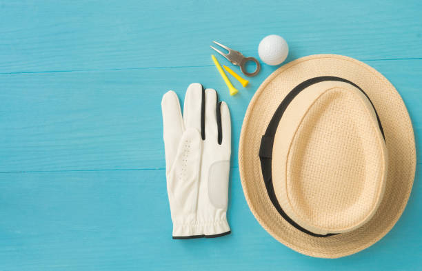 Golf concept : panama hat, glove, golf balls, golf tees, divot repair tool on wooden table. Flat lay with copy space. stock photo