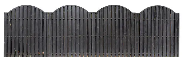 Solid wooden fence of black color. The top line is executed in the form of arches. Isolated on white panoramic collage