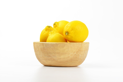 bowl of ripe lemons on white background
