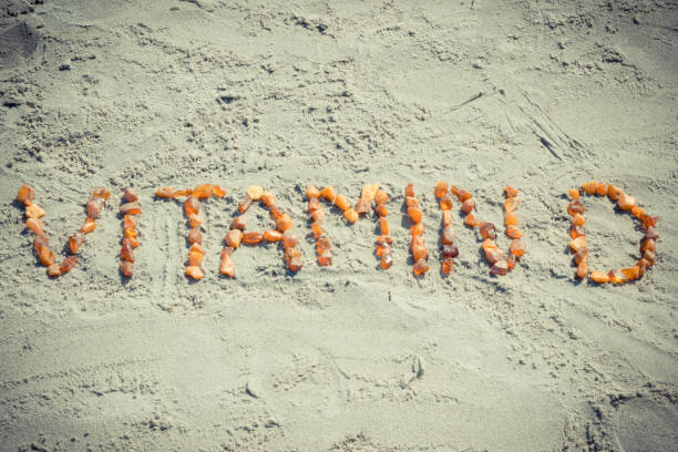 Inscription vitamin D on sand at beach, summer time and healthy lifestyle stock photo