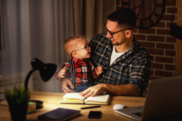 istock father and son baby work at home at computer in dark 672757944