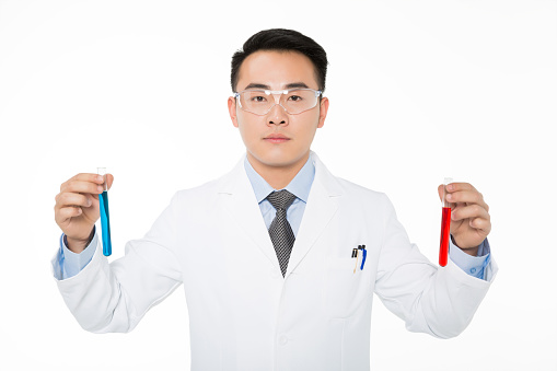 young male researcher holding two test tubes in laboratory
