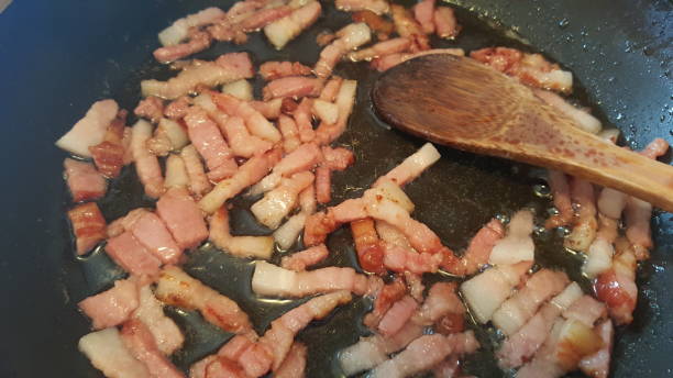 istock Frying bacon in a frying pan 672767374