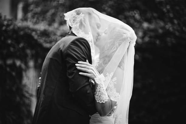 istock Kissing wedding couple under the veil 672767510