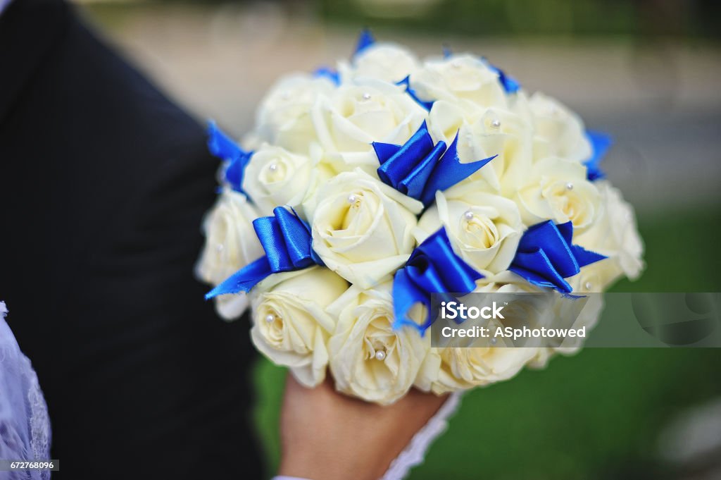 Foto de Buquê De Casamento Com Rosa E Azul Fita Branca Na Mão Da Noiva e  mais fotos de stock de Amarelo - iStock