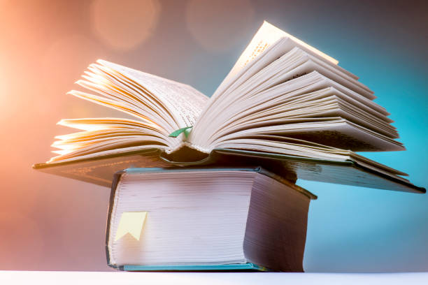 istock Open book on a blue background, bright surroundings. 672778700