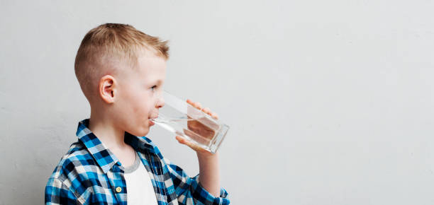 child drinks pure water stock photo
