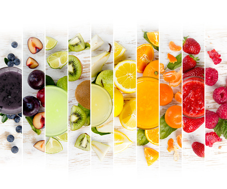 Top view of rainbow colorful mix stripes with fruit, drinks and slices; healthy eating concept; white space for text