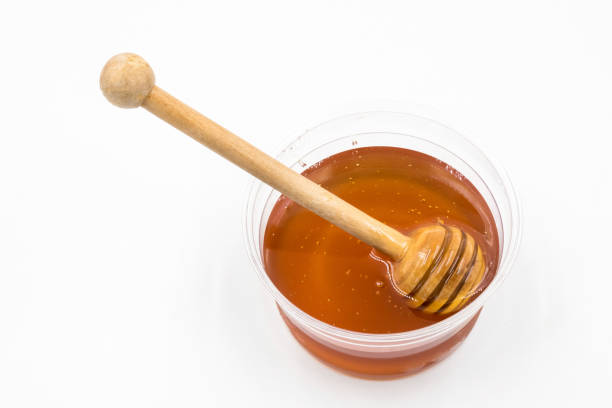 istock Honey with wood stick on white background. 672788878