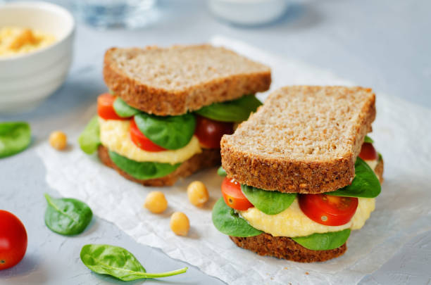 istock rye sandwiches with hummus, spinch and tomatoes 672798976