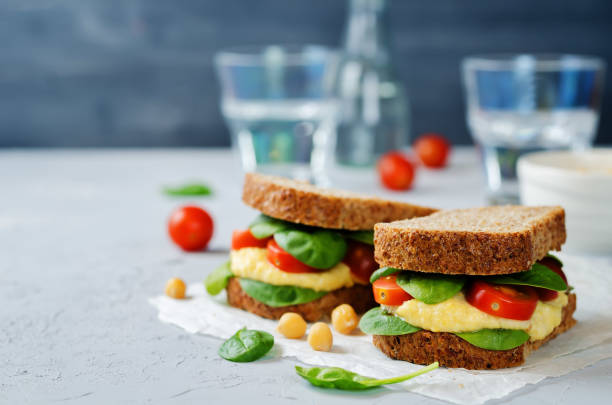 istock rye sandwiches with hummus, spinch and tomatoes 672798984