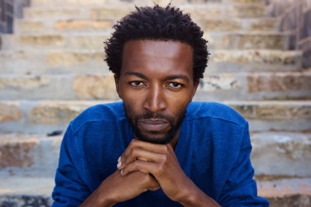 istock serious african man sitting on staircase 672810454