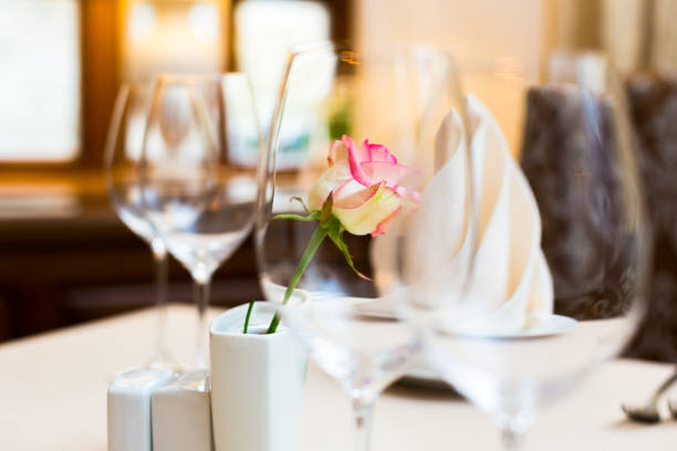 istock Pink rose in a vase as table decoration. Table setting 672810644