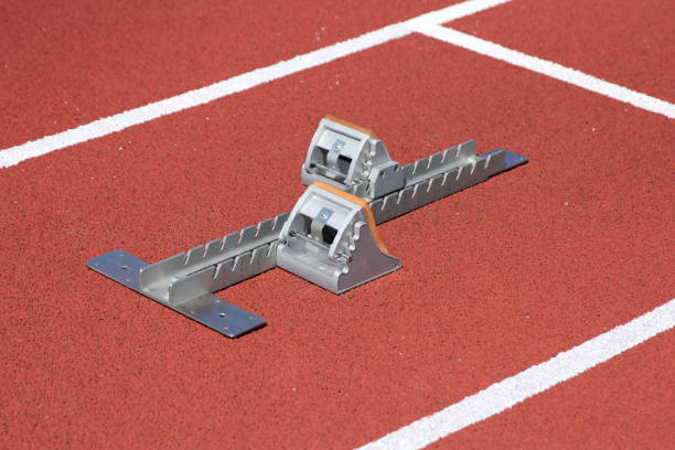istock Athletics starting blocks on race red track 672810692