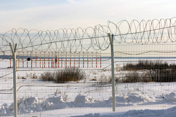 aeropuerto de antenas para una cerca de alambre de púas en invierno - winter wire barbed wire protection fotografías e imágenes de stock
