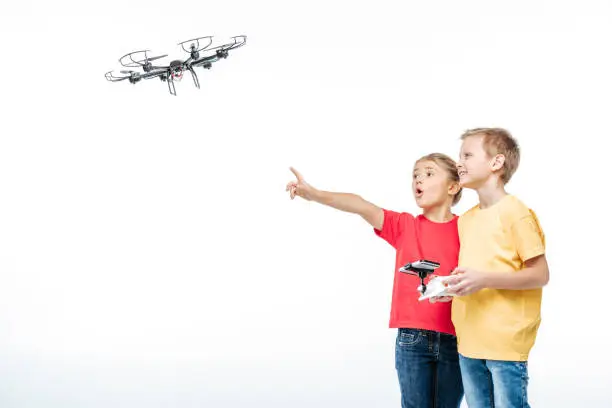 Children playing with flying hexacopter drone isolated on white