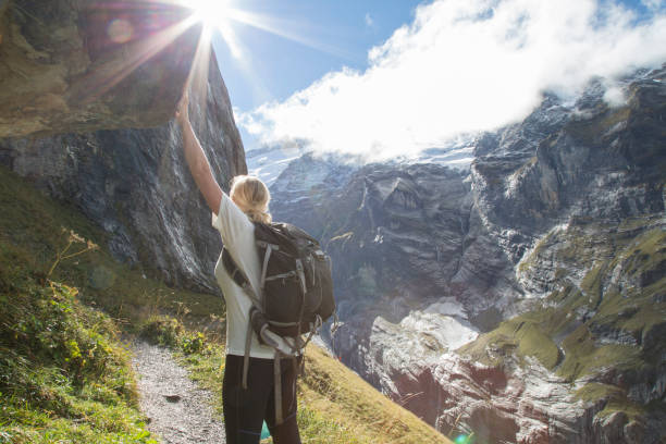 istock Woman admires sunshine and mountains while hiking 672817855