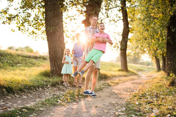 istock Boy shines with happines as his father rotates him in circles. 672823572