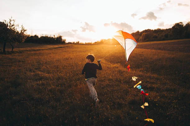 little boy running a kite - child rear view running nature imagens e fotografias de stock