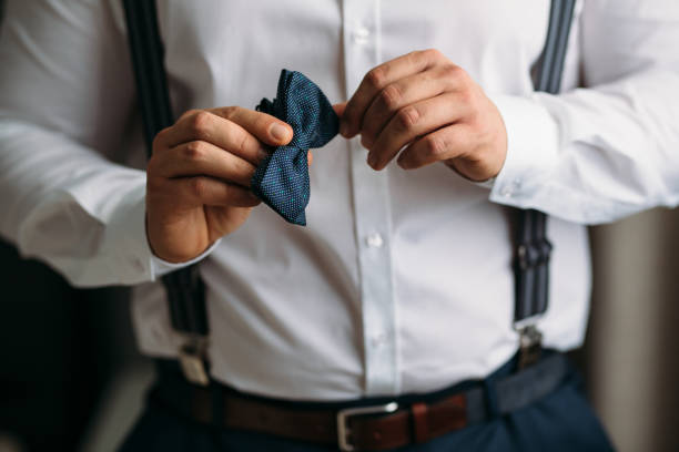 istock Man holding bow tie. Elegant gentleman clother. 672827346