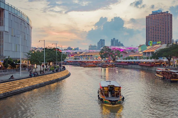 Singapore, Singapore - July 3, 2015: View of tourist boat floating on Singapore river with downtown buildings in the background.
