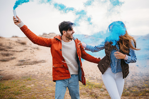 Couple running around with a smoke bomb in their hands.