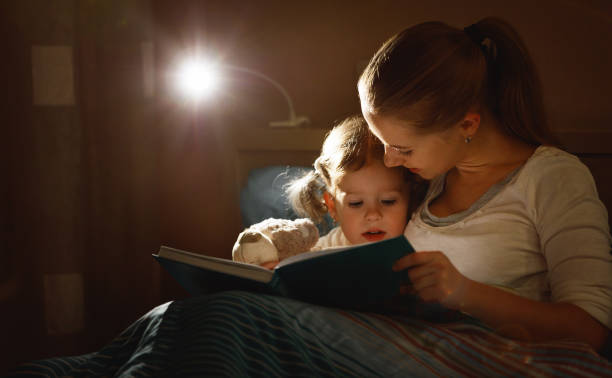 istock mother and child reading book in bed before going to sleep 672836884