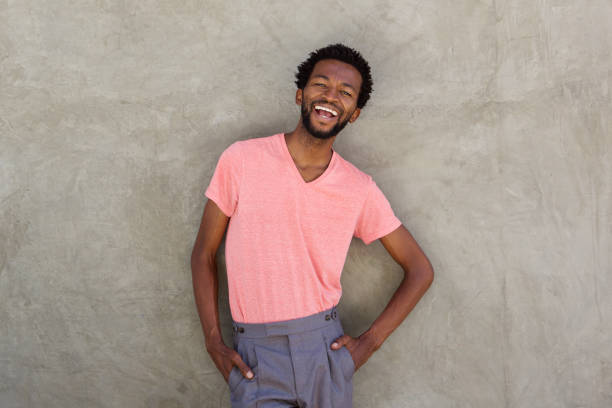 istock attractive african man smiling by wall 672845794