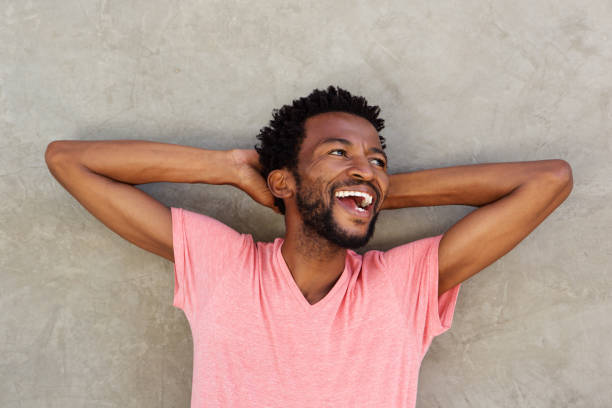 istock Close up attractive african man laughing with hands behind head 672845824