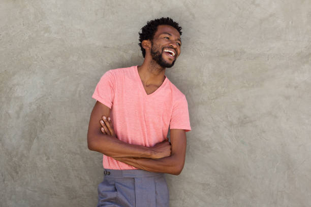 istock handsome african man laughing with arms crossed 672845892