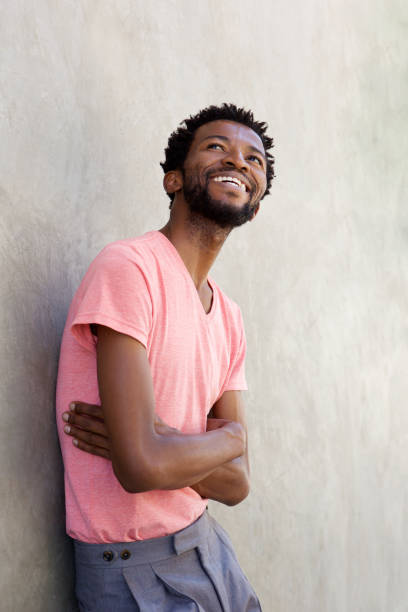 istock handsome african american man laughing with arms crossed 672846008