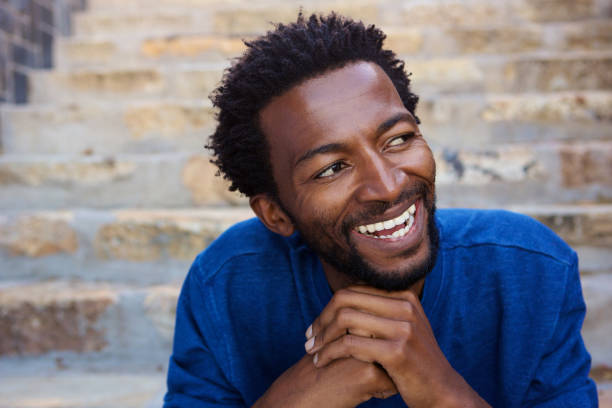 istock smiling african man sitting on staircase 672846116