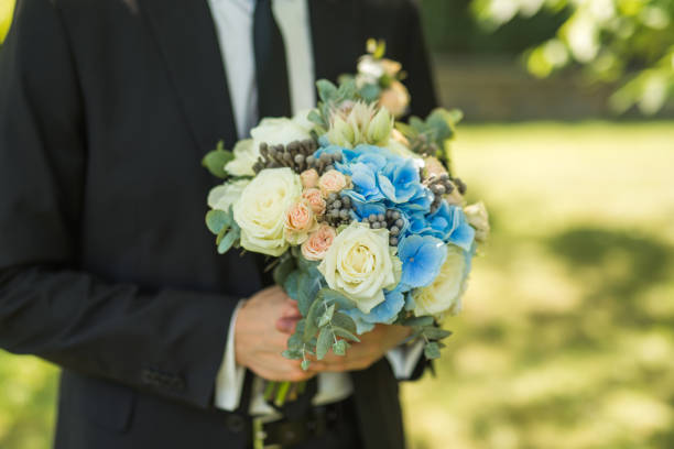 istock groom holding a modern bouquet 672846142