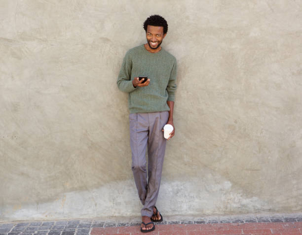istock Full body handsome african man with mobile phone and coffee cup 672846332