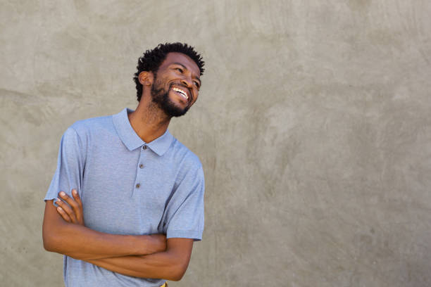 istock handsome afro american man smiling with arms crossed 672846416
