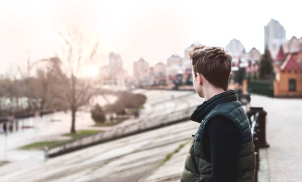 istock Sad young man standing on a city street 672854900