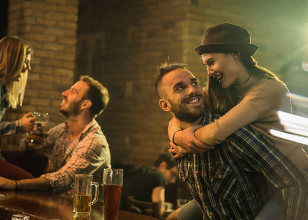 istock Playful couple having fun during the night out in a pub. 672875644